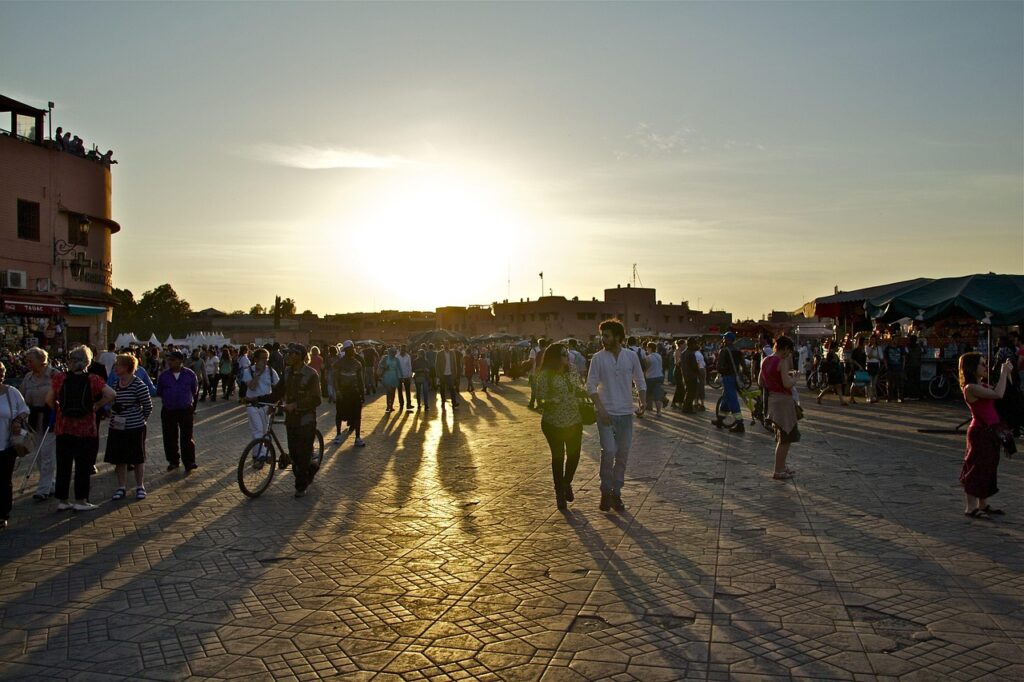 Sunset over Jemaa el-Fnaa square with people walking and enjoying the evening in Marrakech
