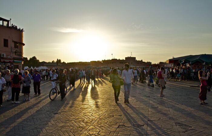 Sunset over Jemaa el-Fnaa square with people walking and enjoying the evening in Marrakech