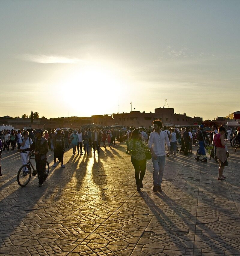 Sunset over Jemaa el-Fnaa square with people walking and enjoying the evening in Marrakech