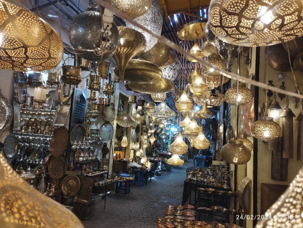 Traditional Moroccan brass lanterns and handcrafted metal lamps in a narrow alley of Marrakech medina