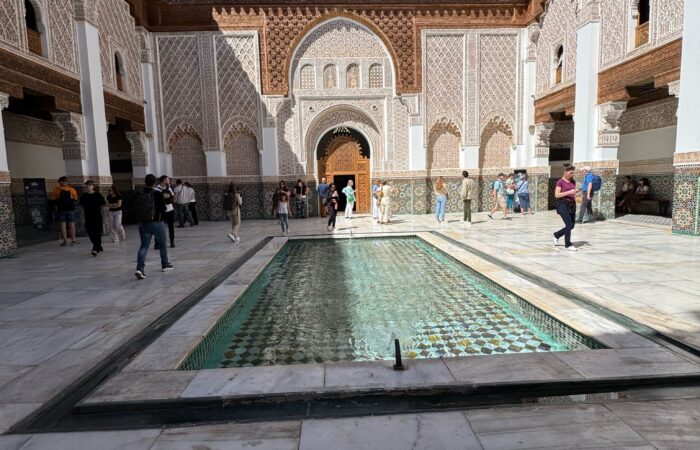 Courtyard of Medersa Ben Youssef in Marrakech with intricate Islamic architecture and a central fountain