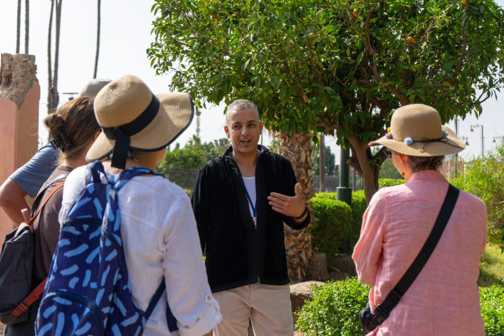 Licensed local guide explaining Marrakech history to travelers during a private guided walking tour